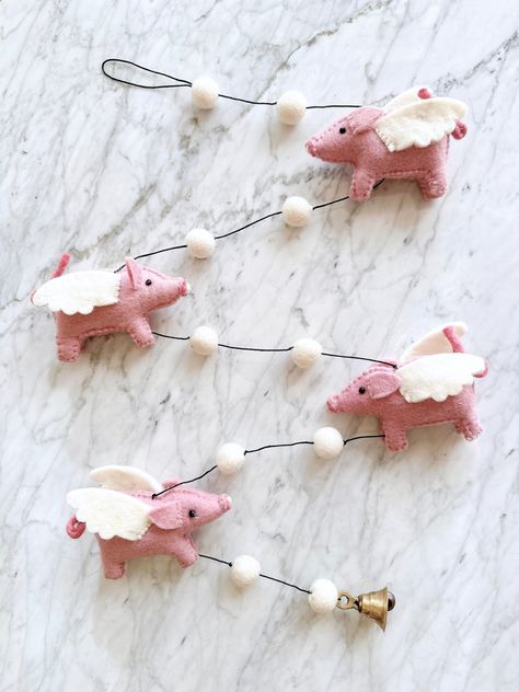 Add a touch of whimsy to your child's room with our dreamy Felt Flying Pig Garland. Handmade with soft, durable wool, this garland features pink piggy birds that soar through the air. Easy to hang and perfect for decorating any space, it's a delightful addition to any nursery. Felt Animal Mobile, Disney Felt Garland, Felt Animal Garland, Felt Garland Diy, Navidad Pink, Pig Wings, Pig Nursery, Felt Bunting Nursery, Micro Pig