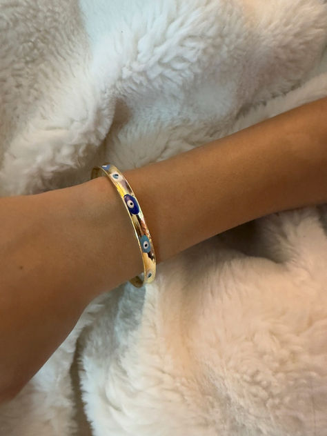 Unleash positive vibes and stylish flair with our Evil Eye bracelet! Featuring the traditional Nazar design, this bracelet is not just a stunning accessory but also a powerful talisman against negativity. Crafted with love and attention to detail, it’s perfect for everyday wear or special occasions. Whether worn alone or stacked with your favorite pieces, it’s a must-have for your jewelry collection. Gift it to a friend or treat yourself to a charm that truly protects! Evil Eye Bracelet Gold, Bracelet Evil Eye, Eye Gift, Evil Eye Design, Luck Charm, Cuff Bangle Bracelet, Wedding Jewelry Bracelets, Protection Bracelet, Luck Charms