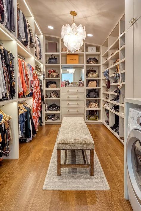 A gray bench sits on a gray runner beneath a glass leaf chandelier and between stacked clothing rails and white built-in shoe shelves. Closet Bench, Master Closet Design, House Closet, Dressing Room Closet, Walking Closet, Dream Closet Design, Walk In Closet Design, Closet Design Layout, Luxury Closets Design