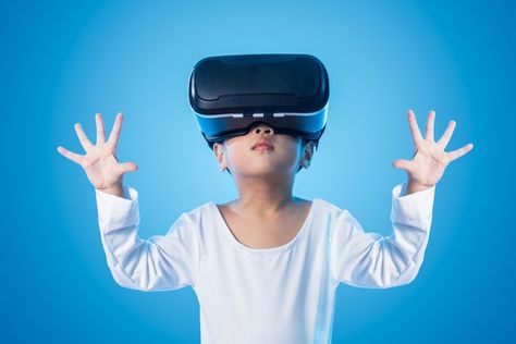 A little boy with a VR headset on in front of a blue screen. Virtual Reality Education, Virtual Reality Design, Augmented Virtual Reality, Technology And Society, Virtual Reality Technology, Virtual Reality Games, Virtual Environment, High Tech Gadgets, Virtual Reality Headset