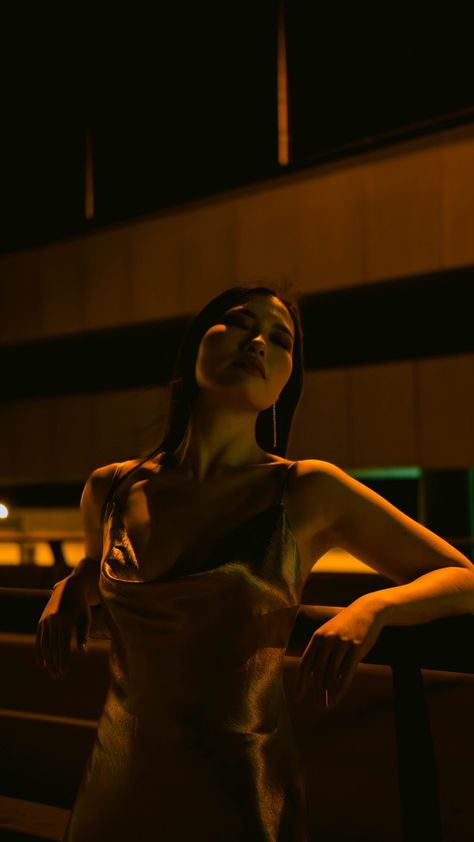 A woman in a gold flowing dress leans back with the orange glow of the streetlight illuminating her face and arms in a cinematic night shot. Night Time Shoot, Street Night Photoshoot, Night Dress Photoshoot, Night City Photoshoot, Night Photoshoot Ideas, Night Time Photoshoot, Siren Photoshoot, Promo Photoshoot, Cinematic Photoshoot