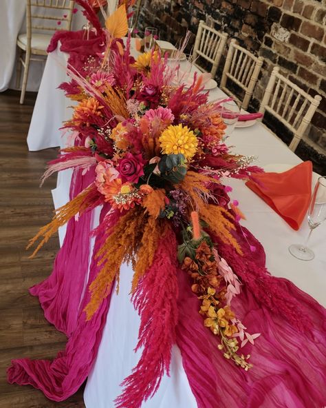 Orange and Pink Wedding Flowers. Set in the beautiful chamblesforth hall and grange. This style was mixed with dried and artificial flowers, and finished with bright pink and orange pampas grass. The table centerpieces were displayed on gold plinths from @kcoevents Added extras finished by the bride 😍 #smallbusinessyorkshire #yorkshiresmallbusiness #weddingcenterpieces #pinkorange #pinkorangewedding #pampascenterpiece #weddingdecor #selby #camblesforthhall #camblesforthhallandgrangewe... Pink Orange Burgundy Wedding, Pink Orange Fall Wedding, Hot Pink Orange Wedding, Purple Pink Orange Wedding, Dholki Night, Orange Wedding Centerpieces, Wedding Table Deco, Dried Wedding Flowers, Orange Wedding Themes