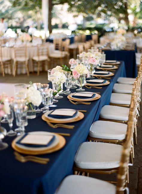 Navy tablecloths with a gold charger, gold-rimmed white plates, navy napkins, custom menus. Crystal vases with blush flowers alternating with gold filigree votives and glass pillars with floating candles Navy Blue And Gold Wedding, Gold Wedding Colors, Rustic Wedding Decorations, Reception Dinner, Navy Blue Wedding, Confetti Party, Wedding Table Decorations, Navy Wedding, Long Table