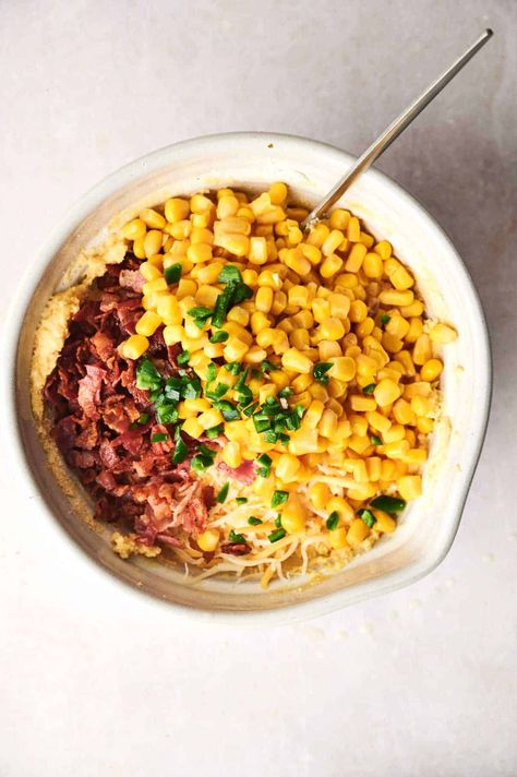 A mixing bowl containing corn, chopped bacon, shredded cheese, chopped green onions, and other ingredients with a spoon—the perfect base for a delicious cornbread casserole. Easy Cornbread Casserole, Cornbread With Cheese, Cracklin Cornbread, Easy Cornbread, Leftover Cornbread, Cornbread Casserole Recipe, Delicious Cornbread, Thanksgiving Potluck, Canning Sweet Corn