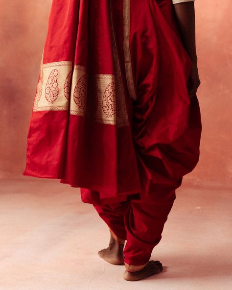 Kachha | Tilfi Drape Series With the saree divided in half, double-knotted at the front waist, and the pallu draped front to back over the left shoulder, this saree drape is a variation from Orissa of the Kachha style.  In frame: a Tilfi pure satin silk Banarasi saree in deep red. It features a plain body, minimal gold zari border, and a classic pallu with floral paisleys. #Tilfi #TilfiSaree #BanarasiSaree #Kachha #Handloom #SareeDrapes #Festive #RedSaree #IndianTextiles Saree Catalogue Shoot, Red Indian Aesthetic, Saree Drape, Silk Banarasi Saree, Indian Designers, Red Indian, Minimal Gold, Red Saree, Indian Textiles