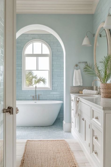 Bring the beach into your bathroom with coastal-inspired decor. Use light, airy colors like white and blue, incorporate natural elements like shells and driftwood, and choose light, breezy fabrics. 🌊🏖️ Blue And White Floral Bathroom, Beach House Bathroom Aesthetic, Bathroom With Light Blue Walls, Coastal Bathroom Design Beach, Blue Coastal Bathroom Ideas, Cute Colorful Bathroom, Colorful Bathroom Remodel, Elegant Blue Bathroom, Colorful Beach House Interior