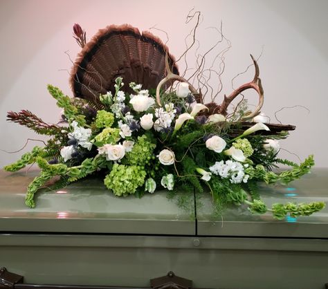 Natural casket spray for an outdoorsman with driftwood, feathers and antlers Condolence Flowers, Sympathy Floral, Casket Spray, Turkey Fan, Casket Flowers, Tulips Arrangement, Deer Horns, Casket Sprays, Grave Flowers