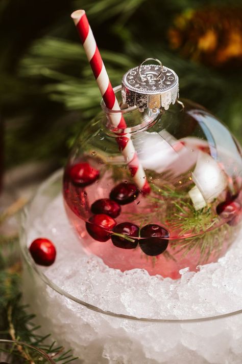 10 Festive Cocktails to Make This Holiday Season Christmas Drinks Decorations, Holiday Drinks In Ornaments, Christmas Bulb Drink Ideas, Christmas Drink In Ornament, Christmas Cocktail Presentation, Christmas Ball Ornament Drinks, Christmas Wedding Drinks, Christmas Drinks In Ornaments, Christmas Cocktails In Ornaments