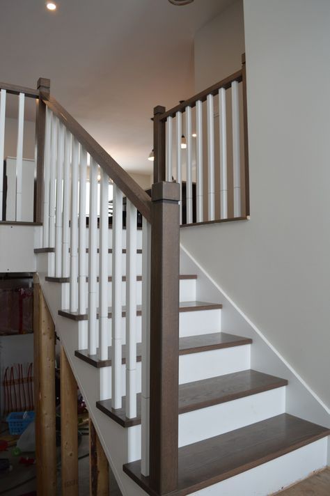 Dark wood and white stairs Dark Handrail White Spindles, Stairwell Wall Ideas, Staircase Update, Raised Bungalow, Handrail Ideas, Bungalow Remodel, Stairwell Wall, Oak Handrail, White Staircase