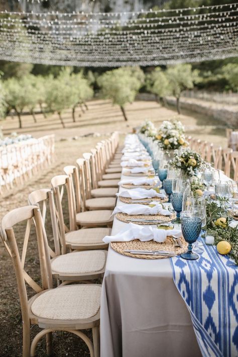 Simple natural blue and citrus yellow wedding table decor and string light set up for finca wedding reception dinner in Mallorca | photo @mariahibbsphotography Mallorca Wedding Table, Mediterranean Table Setting Wedding, Greece Table Decor, Yellow And Blue Table Decor, Lemon Wedding Table Decor, Blue And Yellow Wedding Table Decor, Mediterranean Blue Wedding, Blue And Yellow Italian Wedding, Yellow Wedding Table Decorations