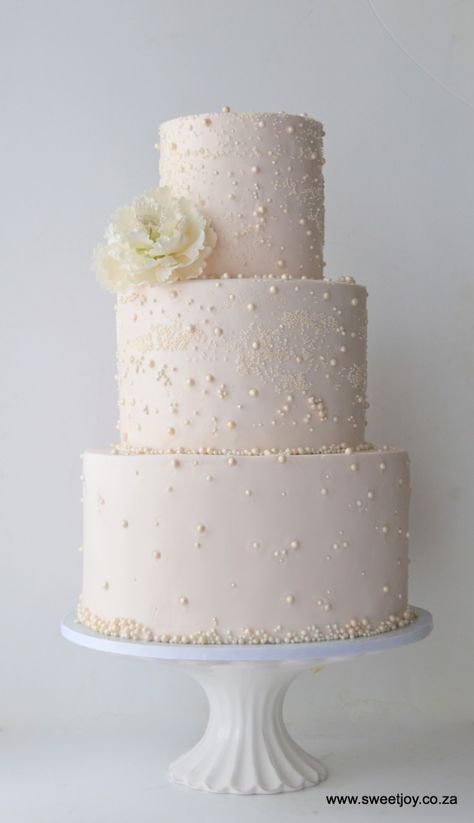 A lovely blush pink wedding cake covered in pearls and topped with a hand crafted sugar peony White Gold Pink Wedding, Pearl Wedding Theme, Romantic Wedding Invites, Cake Quinceanera, Blush Pink Wedding Cake, Pearls Wedding Theme, Champagne Wedding Cakes, Peony Cake, Blush Pink Bridal Shower