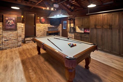 The pool table sits center stage in the room. A tv is mounted in one corner, custom cabinetry fills one side wall. The vaulted ceiling with its exposed beams helps make the space feel more open. Garage Pool Table, Game Room With Pool Table, Rustic Tv Console, Garage Game Rooms, Pool Table Room, Game Room Basement, Garage Door Makeover, Garage Makeover, Billiard Room