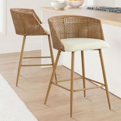 This coastal-inspired counter stool set adds a breezy, textured look to your kitchen or dining area. Each stool features a full back with a natural rattan backrest and armrests that are both breathable and stylish. Supported by sleek metal legs with a wood-inspired finish, these stools boast a modern aesthetic that complements your space. The gently curved chair back and foam-padded seat are upholstered in beige boucle fabric, providing a cozy spot for you and your guests. Complete with a footrest and metal glides for floor protection, these counter stools are not only fashionable but functional, too. | Bay Isle Home™ Arm Counter Stool Upholstered / Wicker / Rattan in Beige | 27" H | Wayfair Rattan Counter Stools, Stools With Backs, Bar Area, Living Room Accents, Counter Bar Stools, Kitchen Stools, Long Hours, Furniture Dining Chairs, Chaise Bar