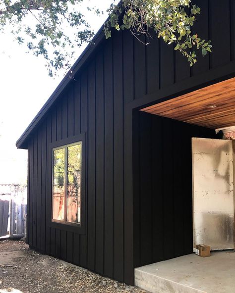 No photo description available. Black Tin House Exterior, Black Metal Board And Batten Siding, Brown Board And Batten Siding, Black Exterior House With Wood Accents, Black Cedar House, Black Siding Exterior, Modular Exterior, Wooden Cladding Exterior, Vertical Siding Exterior