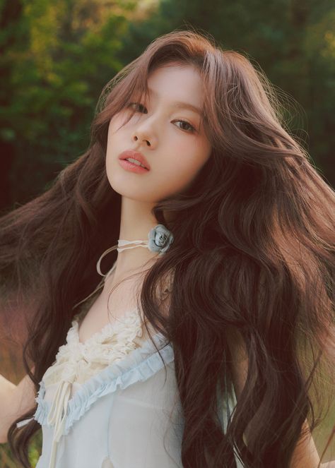 Minatozaki Sana, cantora japonesa está em um campo com árvores e flores. Ela segura algumas mechas de cabelo e usa um vestido azul e gargantilha com uma flor azul. Twice Photoshoot, Sana Minatozaki, Sana Momo, Minatozaki Sana, Twice Sana, Kpop Posters, Set Me Free, Iconic Photos, I Got You