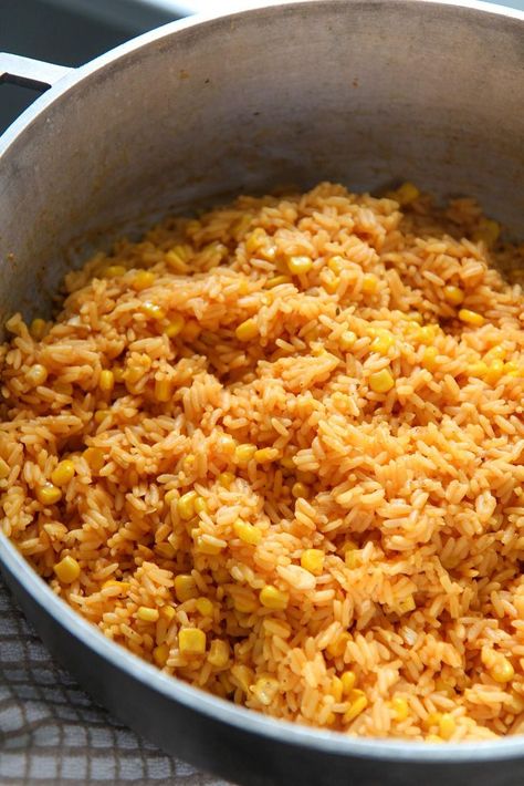 This yellow rice with corn is cooked with onions, garlic, spices, and vino seco. A Cuban staple that can be enjoyed with tomato avocado salad and pernil. Super easy to make and will feed a large crowd. #sidedish #yellowrice Rice With Corn Recipe, Rice And Corn Recipe, Spicy Corn Dip, Rice With Corn, Yellow Rice Recipe, Rice And Corn, Yellow Rice Recipes, Parboiled Rice, Honey Roasted Carrots