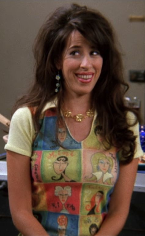 Maggie Wheeler as Janice from 'Friends' (1994) S3 E4 'The One With The Metaphorical Tunnel' (1996) wearing a short sleeved, collared top decorated with colorful artistic panels of faces. Fur Coats Outfit, Nanny Aesthetic, Janice Friends, Maggie Wheeler, Curly Hair Brunette, Outfit Inspo 90s, 90s It Girl, Aesthetic Eyeshadow, Coats Outfit