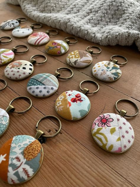 Gathered up some of my favorite bits of fabric to create these pretty key rings.  Each is made to be like a mini quilt, there are 20 included in this.  First I stitch up tiny little crazy quilts that are them made into buttons.  Next they are inlaid on a metal bezel and suspended from a keyring. Each bezel measures 1.5 inches and comes suspended from a 1 inch split ring. This listing is a bulk grouping of my quilt keychains.  I created this for when you need a little token of appreciation for la Quilted Jewelry, Sew Gifts, Fabric Keychain, Sewing Machine Repair, Quilt Retreat, Keychain Fob, Handmade Ideas, Tree Ideas, Hair Stuff