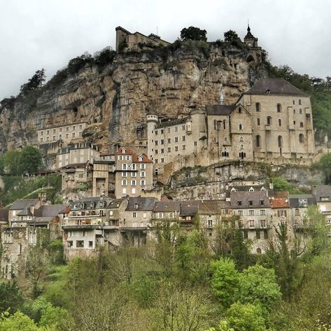 the medieval village of rocamadour, a sacred town perched on the side of a limestone cliff. val du lot. occitanie. france Medieval Mountain Village, Mountain Side Village Minecraft, Cliff Side Castle, Minecraft Cliff Village, Mountain Side Village, Cliff City, Rocamadour France, Story References, Fantasy Journal