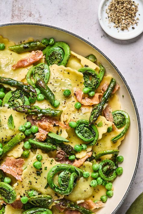 This springtime ravioli dish is full of market fresh ingredients in a simple and delicious lemon butter sauce. Roasted veggies include local in season asparagus and fiddleheads which get tossed into the pasta with the peas and prosciutto. This ravioli dish is so simple to make and truly THE best any night of the week dinner but especially the midweek when you want something quick but delicious for dinner. Dinner Recipes Ravioli, Recipes Ravioli, Asparagus And Peas, Spring Veggies, Homemade Ravioli, Cheese Ravioli, Lemon Butter Sauce, Roasted Asparagus, Lemon Butter