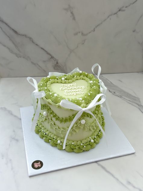 Sage green vintage heart cake with white bows and pearls Green Heart Birthday Cake, Green Cakes Ideas, Green And Pink Heart Cake, Smiski Cake, Green Sweet 16 Cake, Light Green Birthday Cake, Green Aesthetic Cake, Sage Green Cake Ideas, Olive Green Cake