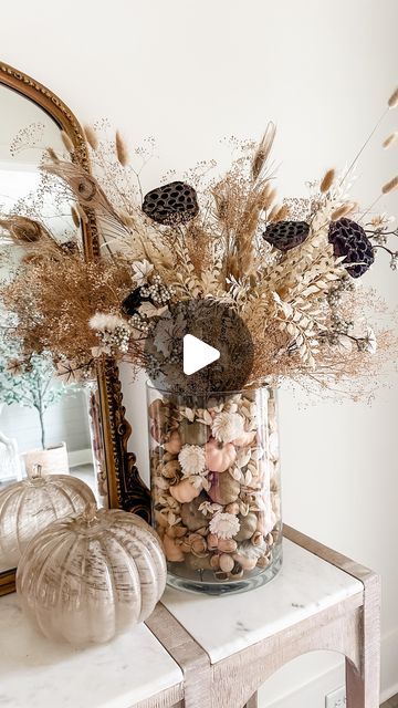 Ashley Savage | Home Decor on Instagram: "Found these oversized glass vases at homegoods and added some pumpkins and potpourri to it. It smells amazing even though I have faux florals in it! I will share details on what I can in my LTK for y’all. Comment SHOP to get details sent straight to your inbox! 🤍🍂 • • • #fallarrangement #pumpkindisplay #pumpkinseason #easydiy #diyfloralarrangement #fallseason🍁 #cozyseason #thanksgivingideas #fallideas #floralcrafts #driedflorals #diyhomedecor #homedec Potpourri Decoration Living Rooms, Tall Glass Vase Decor, Fall Decor Glass Vase, Pumpkin Dried Flower Arrangements, Potpourri Display, Mini Pumpkin Dried Flowers, Dried Floral Pumpkin Arrangement, Large Glass Vase Filler Thanksgiving, Potpourri Decoration