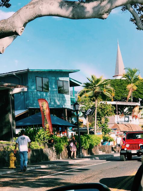 Driving down a small road in Hawaii. There’s a bright blue building on the left with a rainbow going over. A red jeep going down the street. Hawaii Film Photography, Hawaii Neighborhood, Kona Hawaii Aesthetic, Beach Town Aesthetic, Kailua Kona Hawaii, Living In Hawaii, Town Aesthetic, Kona Hawaii, Hawaii Homes