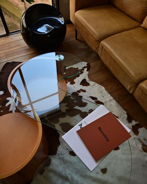 Choosing pieces for our studio’s meeting room was a joy for the sake of interior design that is a huge part of identity of House of Rowdy. Each item, from the cozy tan leather sofa to the unique glass-top coffee table, was selected to create a space where creativity thrives. The abstract artwork by @rosemadone and cowhide rug is to add a touch of rustic charm, blending with the modern aesthetic of our industrial space. Every detail is to reflect our passion for design and the pleasure of cra... Coffee Table Aesthetic, Cowhide Rug Living Room, Tan Leather Sofa, Office Redesign, Tan Leather Sofas, Hangout Spot, Industrial Space, Cow Skin, Glass Top Coffee Table