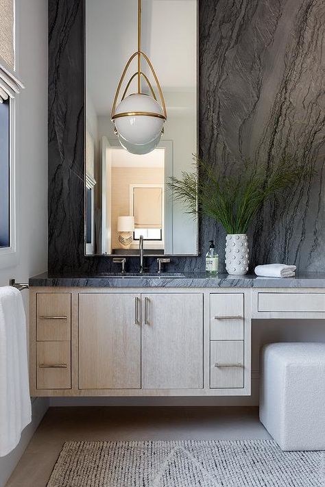 Bathroom features a tan brushed oak floating washstand with black marble countertop under a tall vanity mirror lit by a white and gold pendant and an off white stool. Modern Classic Bathroom, Vanity Nook, Wood Spa, Marble Counters, White Marble Bathrooms, White Stool, Marble Vanity, Bathroom Design Inspiration, Classic Bathroom