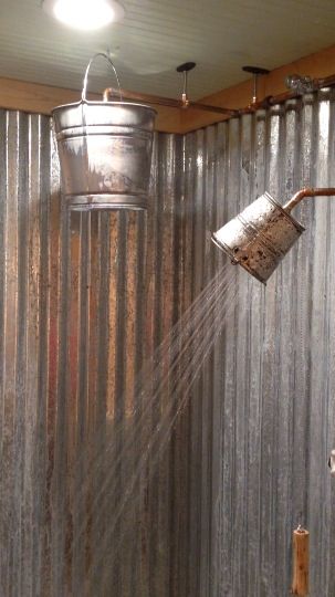 The small bucket is a shower head, the large one is a rain head with a pull valve. You can see the video on Facebook at J and L Construction. Rustic Shower Head Ideas, Corrugated Metal Shower Walls Diy, Galvanized Shower Walls, Tin Shower Walls Rustic Bathrooms, Tin In Shower Rustic Bathrooms, Galvanized Shower, Outhouse Bathroom, Rain Head, Rustic Shower