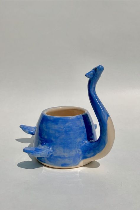 Lochness Monster, Monster Animal, Cozy Reading Chair, Ceramic Monsters, Ceramic Cafe, Dinosaur Mug, Chair Ideas, Ceramic Pieces, Animal Mugs