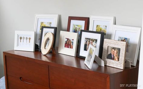 All your photo frames in one place can leave your surfaces feeling cluttered Picture Frame Arrangements, Displaying Family Pictures, Frame Arrangement, Picture Frame Table, Photo Frame Decoration, Picture Arrangements, Picture Table, Photo Arrangement, Family Picture Frames