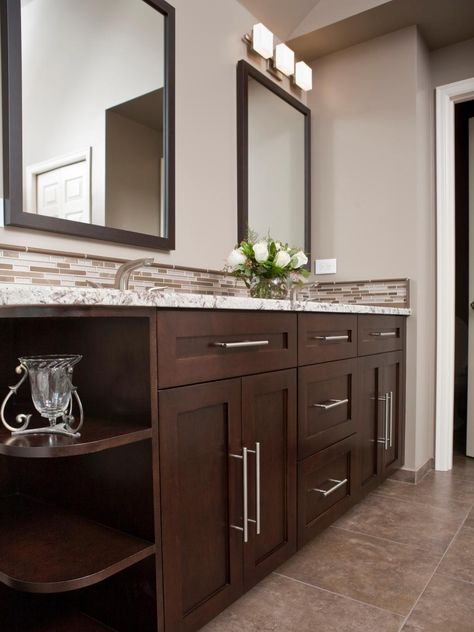 The mix of classic dark wood, oversized modern brushed-nickel drawer and cabinet pulls, and granite countertops lends a timeless feel to this master bathroom. It offers plenty of storage for two people to stash clutter, keeping the room neat and tidy. Photography and design by Nip Tuck Remodeling Dark Vanity Bathroom, Dark Cabinets Bathroom, Bathroom Cabinet Colors, Makeover Kamar Mandi, Dark Wood Bathroom, Wood Bathroom Vanity, Brown Cabinets, Brown Bathroom, Vanity Design