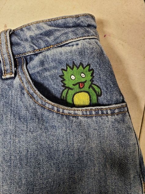 Monster Jeans paint Paint On Blue Jeans, Painting On Pockets Of Jeans, Fabric Paint Designs On Jeans, Diy Pants Design Paint, Painted Jean Shorts Pockets, Fabric Painting Jeans, Painting On Shorts Ideas, Draw On Jeans Pants, Jean Pants Painting Ideas