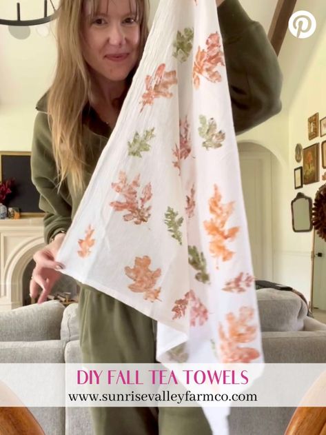 A woman holding up a white tea towel decorated with orange and green leaf prints. The bottom text reads "DIY Fall Tea Towels" with a link to sunrisevalleyfarmco.com. Painted Tea Towels, Tea Towel Diy, Diy Tea Towels, Tea Towels Crafts, Kitchen Towels Crafts, Tea Towels Diy, Diy Mural, Large Pumpkins, Diy Tea