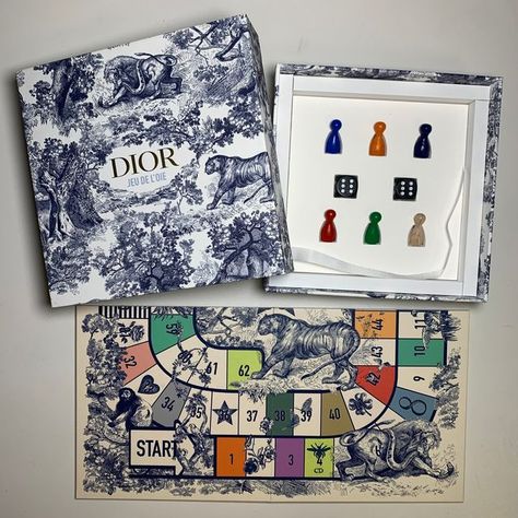 Thomas J. Watson Library on Instagram: "This beautiful box was sent out by Dior as the invitation to their Spring/Summer 2022 show, presented in Paris. Once unpacked the box contains a colorful gameboard, game pieces, and the rules of play card for the game Jeu de l’Oie. More unique items that are sent out as fashion show invitations can be found in @costumeinstitutelibrary!  #MetLibrary #MetCostumeInstitute #CostumeInstituteLibrary #Boardgame #Boardgames #BoardGameDesign #FrenchGames #Dior #FashionShow #FashionShowInvite #FashionShowInvites #SpringSummer22 #HauteCouture #FrenchFashion #Boxes #Toile #ToileArt #ToileAddict #Oie" Playing Card Packaging, Unique Board Games, Boardgame Design, Fashion Invitation, Fashion Show Invitation, Board Game Box, Play Card, Board Game Design, Cards Game