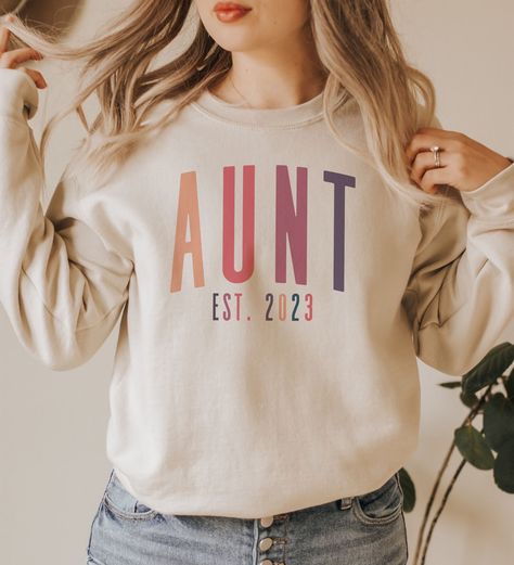 Join the Cool Auntie Club and show off your auntie status with our Custom Aunt Established Sweatshirt! This fun and quirky top features the word "Aunt" and the year you became an aunt, making it the perfect way to celebrate your memories. It's also a great gift for your sister and a sweet way to show her you're her favorite auntie. Whether you're hanging out with your nieces and nephews, running errands, or just lounging at home, this sweatshirt is sure to keep you comfortable and stylish. So, w Family Sweatshirts, Aunt To Be, Aunt Sweatshirt, Adoptive Mom, New Aunt, Gifts For Your Sister, Foster Mom, Mama Shirts, Mama Sweatshirt