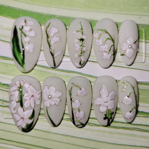 Set of almond shaped press-on nails with hand-painted white florals over a sheer cream coloured base. Tiny 3D pearls are on two of the flower centers. Comes with 1 sheet of nail adhesive tabs (24 pcs). -If you wish to purchase this design in a different shape or length, please message me prior to purchasing so I can accommodate your preference. Please do not order sets of 10 if you are not confident in what your nail sizes are, as I do not want you to receive nails that do not fit properly Lily Of The Valley Nail Designs, Clear Nails White Flowers, Lily Of The Valley Nails, Floral Pearl Nails, Hangyodon Nails, White Flower Nail Art, Almond Nails Pressed Flowers, Japanese Floral Nails, Magenta Nails