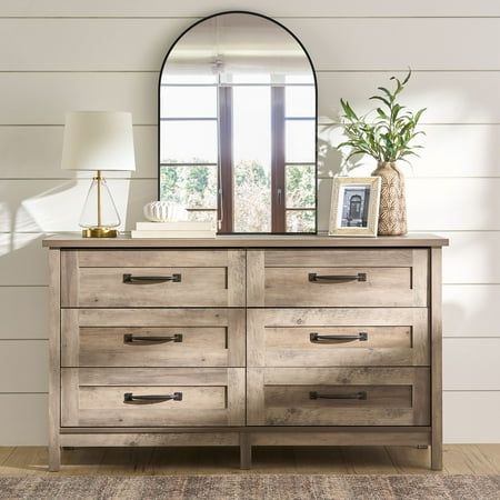 Create a rustic-inspired look while adding versatile storage options to your bedroom with this dresser from the Better Homes & Gardens Modern Farmhouse collection. This beautiful chest of drawers features six easy gliding drawers that open and close on smooth metal runners, making them ideal for convenient storage of an array of different items like stacks of button-up shirts and blue jeans to your collection of old t-shirts and sweat pants. It has room for all your stuff! Its spacious top surface provides you with additional space to store bedroom items and display your favorite home decor like an accent lamp, your makeup bag, bottles of perfume, and pictures of your family and friends. Its simple design and charming, good looks make this dresser a perfect fit for your bedroom. Finished i Dresser Top Decor, Dresser Rustic, Dresser Styling, Top Of Dresser, Dresser Decor Bedroom, Bedroom Decoration Ideas, Farmhouse Dresser, Modern Farmhouse Bedroom, Beautiful Dresser