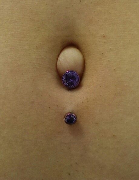 Lower navel piercing with a titanium bezel set navel curve with amethyst CZs. Anodized vibrant purple by us. Jewelry from @Intrinsic. #navelpiercing #titaniumbodyjewelry #bodypiercing Reverse Navel Piercing, Belly Button Piercing On An Outie, Outie Belly Button Piercings, Outie Belly Button, Lower Navel Piercing, Bellybutton Piercings, Belly Button Piercing Jewelry, Body Organs, Navel Piercing