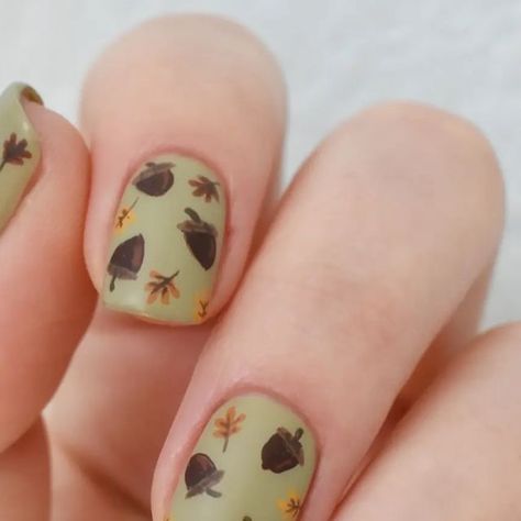 Nail Art by Amber on Instagram: "🌰 🍂 Just a simple little acorn and fall leaves design. I like how everything turned out, except on the thumb nail. For some reason, I kept the acorns and leaves very small. Even on my second try. Don't know why. Anyway, the weather is starting to cool down, and I couldn't be more excited for it. How about you all? . . . Products Used: @zoyanailpolish 'Ireland', 'Emilia', 'Dionne', 'Colin', 'Chanelle', 'Honey' . @essie 'Kaf-tan' . @sally_hansen Big Matte top co Acorn Nail Art, Acorn Nails, Fall Leaves Design, Plain Nails, Leaves Design, Autumn Nails, Sally Hansen, Fall Leaves, Leaf Design