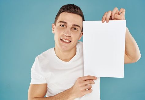 Young man holding a sheet of paper with ... | Premium Photo #Freepik #photo #holding-sign #holding-banner #holding-paper #business-executive Anime Holding Paper, Person Holding Paper Reference, Person Holding Sign, Man Holding Paper, Holding A Piece Of Paper, Mtn Logo, Holding Sign, Holding Paper, Holding A Sign