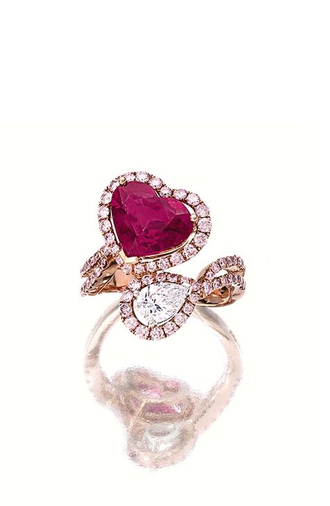 RUBY, DIAMOND AND PINK DIAMOND RING, Of crossover design, set with a heart-shaped ruby weighing 3.38 carats and a pear-shaped diamond, surrounded by circular-cut pink diamonds extending to the shank, mounted in 18 karat pink gold. Bypass Rings, Valentine Jewellery, Pink Gold Ring, Pink Diamond Jewelry, Heart Shaped Ring, Pink Diamond Ring, Ruby Birthstone, Buying Gold, Pink Diamonds