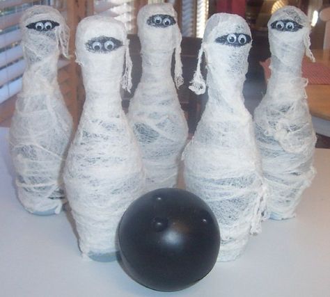 Mummy Bowling.  Took a kids plastic bowling set, painted pins black, wrap with glue/starch soaked gauze and add eyeballs. I did this for a pre-school fall festival. Now I just use them (minus the ball lol) for indoor/outdoor Halloween decor.                                                                                                                                                                                 More Preschool Fall Festival, Mummy Bowling, Fall Carnival Games, Fall Festival Activities, Halloween Carnival Games, School Fall Festival, Fall Festival Games, Outdoor Halloween Decor, Fall Harvest Party