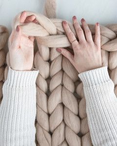 hands weaving top row of arm knit blanket Arm Knitting Blanket Diy, Arm Knit Blanket, Arm Crocheting, Clothes Folding, Diy Knit Blanket, Hand Crocheted Blanket, Folding Board, Knitting Blanket, Arm Knit