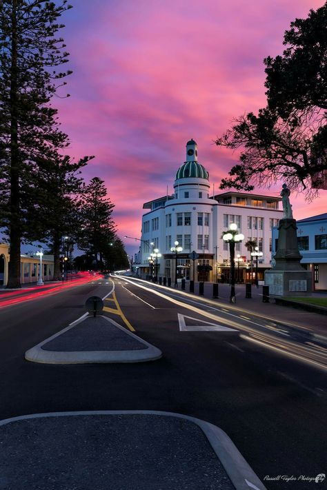 '5 o'clock hometime'  This is my take on an iconic Napier Art Deco building called The Dome Napier. The pink from the sunset and the light trails  really lead you into the heart of the shot.  Napier i-SITE Visitor Centre Hawke's Bay New Zealand Napier Art Deco, Sunset Building, Napier New Zealand, Building Aesthetic, Art Deco Buildings, Light Trails, Disney Magic Kingdom, Pink Sunset, The Shot