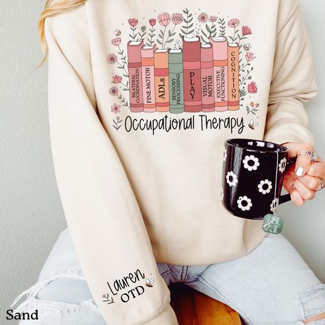 This personalized wildflower occupational therapy sweatshirt is the perfect custom gift for any OT or OTA! Available in either a cozy sweatshirt or a comfy t-shirt that both fit like a well-loved favorite. The crew neckline adds a classic, neat style that's perfect for accessorizing. SHIRT INFORMATION & SIZING: The sweatshirt option is a Gildan Heavy Blend Crewneck sweatshirt made from a blend of 50% cotton and 50% polyester. Unisex Adult Sizing - please see the sizing chart in the listing photos to determine the best size for you. It can be helpful to measure one of your favorite shirts then compare it to the size chart before placing an order. The t-shirt options is a Bella+Canvas Tee is a unisex shirt - please see the sizing chart in the listing photos to determine the best size for you Physical Therapy Assistant, Speech Therapy Shirts, Sped Teacher, Bella Canvas Tees, Grad Gifts, Cozy Sweatshirts, Speech Therapy, Unisex Shirt, Graduation Gifts