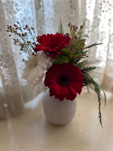 White and red daisies with greenery in a small round vase Red And White Floral Centerpieces, Red And White Floral Arrangements, Red And White Flower Arrangements, Simple Floral Centerpieces, White Flower Centerpieces, Red Flower Arrangements, White Centerpieces, White Floral Centerpieces, White Floral Arrangements