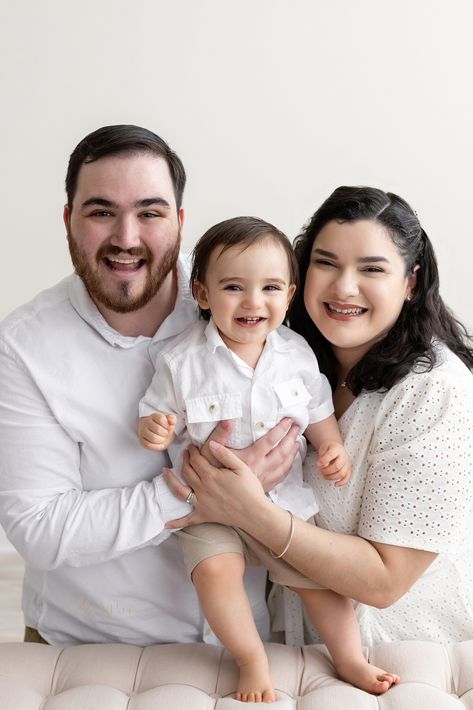 Family first birthday photo of a happy one-year-old boy as he stands on a tufted bench between his parents taken next to a window streaming natural light in a studio near Kirkwood in Atlanta, Georgia by Lily Sophia Photography. 1st Birthday Boy Pictures, 1st Birthday Photoshoot With Parents, First Birthday Family Photoshoot, One Month Old Baby Pictures, Parents Photo, Birthday Poses, Family Potrait, Baby Family Pictures, First Family Photos