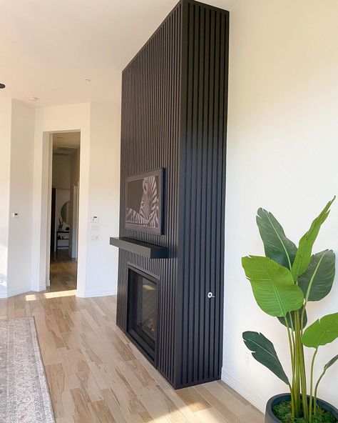 Black Fireplace Mid Century, White Walls With Feature Wall, Black Fluted Fireplace Wall, Feature Wall Above Fireplace, Black Herringbone Fireplace Surround, Black Wood Slat Fireplace Wall, Wooden Slat Fireplace, Black Fireplace Vaulted Ceiling, Vertical Fireplace Ideas